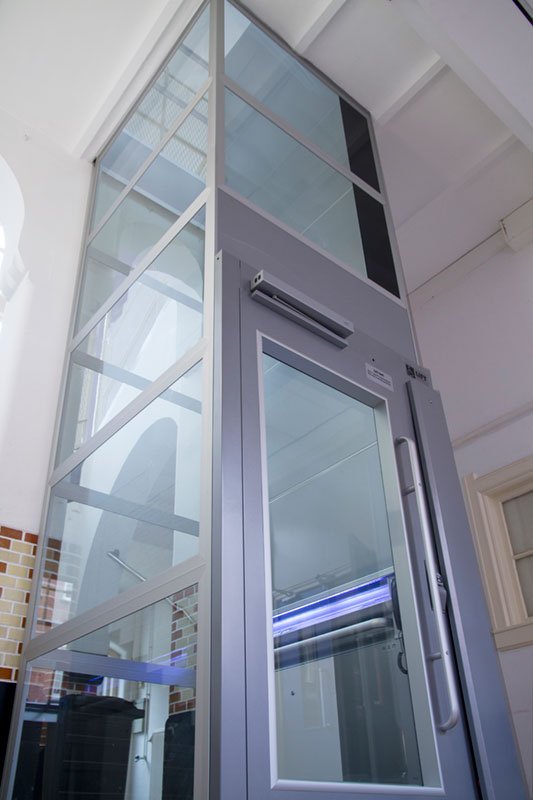 Vrijstaande liftschacht met glazen wanden