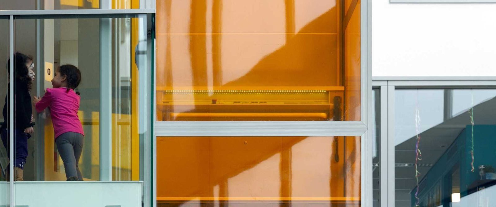 Platformlift met gekleurde glazen schacht